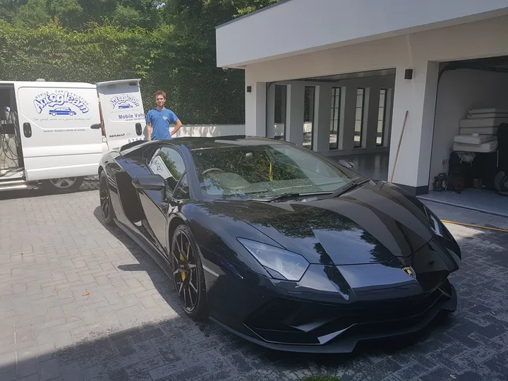Black Lamborghini Aventador on a driveway with our valeter and the Auto Gleam van behind it